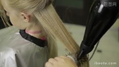 美发师用吹风机和圆刷吹干女孩的长金色直发